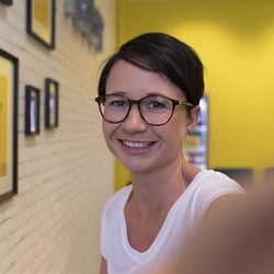 Female Trusted Shops employee smiles for a Selfie.